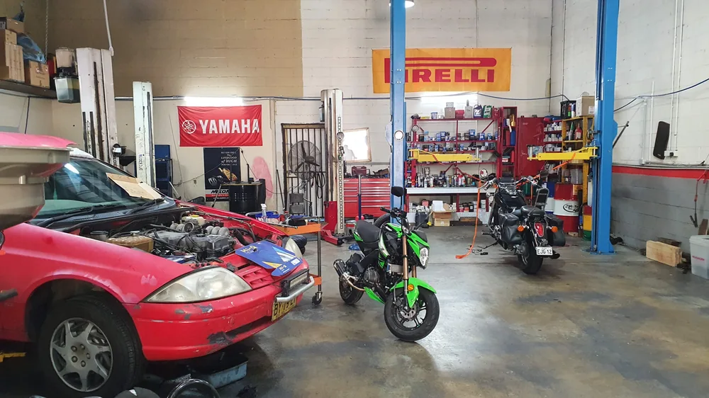 Cars and a motorcycle inside the Thornleigh Motor Repairs workshop